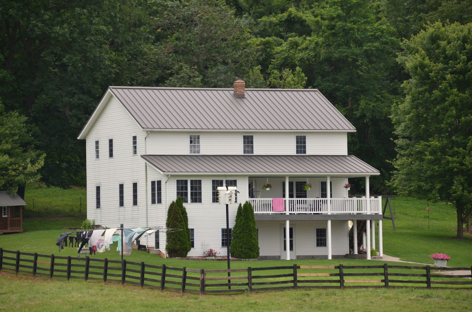 A white house sits in a green, rural landscape.